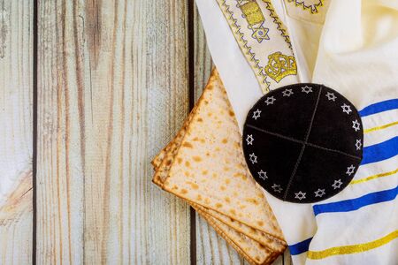Passover matzoh jewish holiday bread kippah and tallit over wooden table background.の写真素材