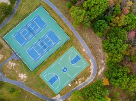 Outdoor tennis green court and basketball field in the park from a height in autumnの写真素材