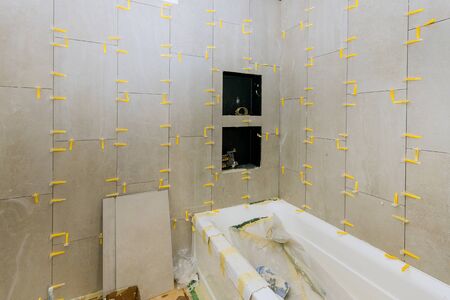 Construction work installing ceramic tile on reconstruction of bathroom during or renovationの写真素材