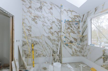 Renovation construction laying floor and wall tile unfinished reconstruction of bathroom