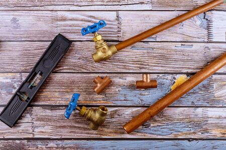 Set of brass plumbing fitting house improvement tools on wooden board