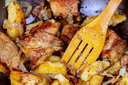 A homemade large grilled pork served in a pan with onion, roasted potatoesの写真素材