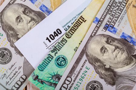 Closeup 1040 Tax form with refund check and currency US dollar banknotes