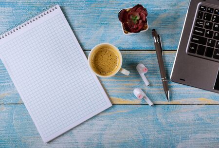 Modern workplace with notepad, headphones, glasses, pen and coffee cup on laptop computer keyboard officeの写真素材
