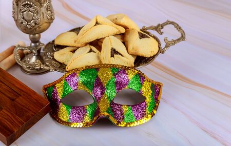 Hamans ears cookies and mask for Purim celebration jewish holiday carnival, noisemaker and kosher wineの写真素材