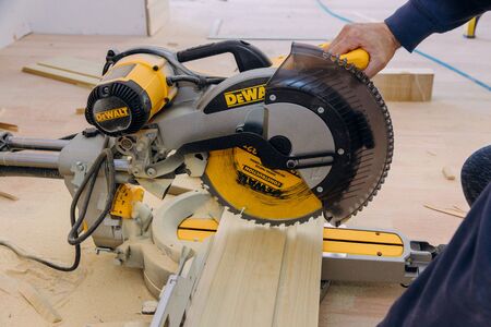Los Angeles CA DEC 20 2019: Power miter saw DeWalt on a cut wooden trim base molding for new house under constructionのeditorial素材