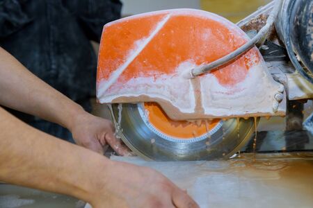 Cutting tiles using a diamond blade saw worker use wet sawing machine for cuttingの写真素材