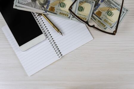 Calculation of financial waste with phone, notebook and pen. Financial concept.の写真素材