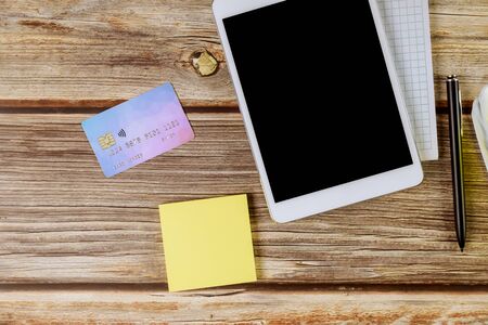 Online shopping using digital tablet and credit card, blank notebook with pen of workspace office...