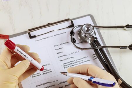 Doctor writing medical records test tube containing MERS-CoV with laboratory test tubeの写真素材