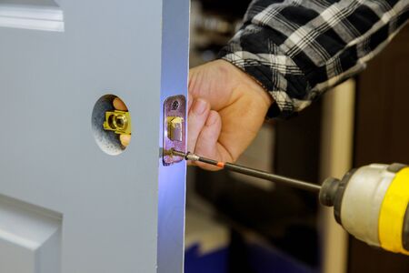 Builder is installing lock a doot in the room installation into wood door