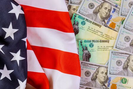 Stimulus American economic tax return check with US flag and USA dollar cash banknoteの写真素材
