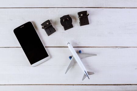 Used to connect to different electrical socket plug adapters outlets worldwide model airplane on flat lay and smartphoneの写真素材