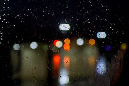 Night in rainy season wet the window with backgroundの写真素材