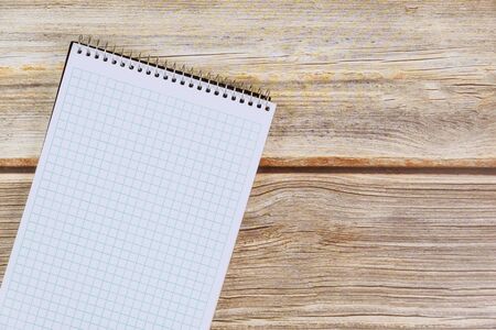 Blank spiral notebook empty white paper page on wood background