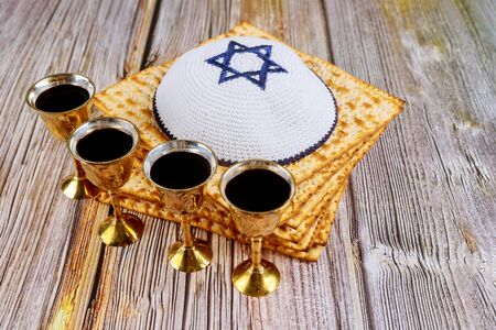 Matzoh jewish holiday red kosher four glasses wine with a of matzah a Passover Haggadahの写真素材