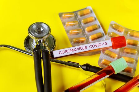 Tube infected blood sample COVID 2019. Corona virus outbreaking medicines tablets on stethoscopesの写真素材