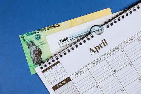 Income tax with form 1040 and spiral calendar April Financial concept.の写真素材