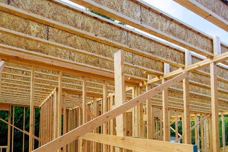 New construction of beam construction house framed the ground up framing against a blue sky