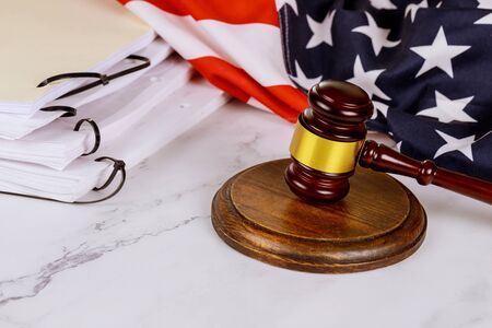 Wooden judge gavel with the United States flag of office paper folders