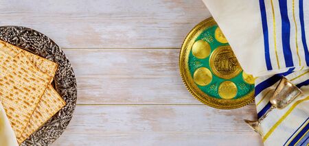 Passover jewish holiday celebration matzah, kiddush and seder with text in hebrew egg, bone, herbs,...