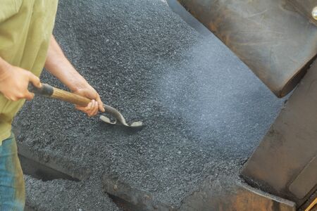 close-up details of industrial machinery working with asphal industrial laying fresh asphalt on...
