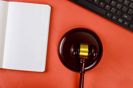 Workplace with notepad and keyboard judges wooden gavel office with lawyerの写真素材