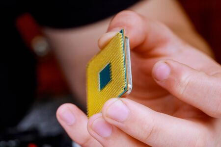 Computer technician installing CPU on motherboard on a personal computer.