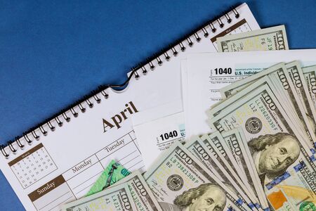 American tax 1040 form and refund check and USA currency hundred dollar bills Pay Tax