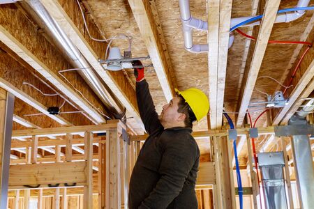 Electrician technician of a spotlight lamp in the ceiling on ceiling indoorsの写真素材