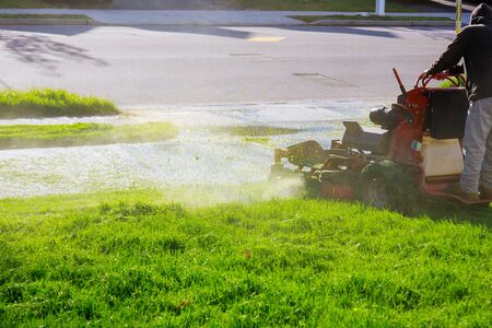 Man worker cutting grass in summer with a professional gardener mowing lawnの写真素材