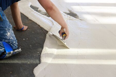 Prepare the cement for construction using trowel to mix mortar unfinished laying floor tilesの写真素材
