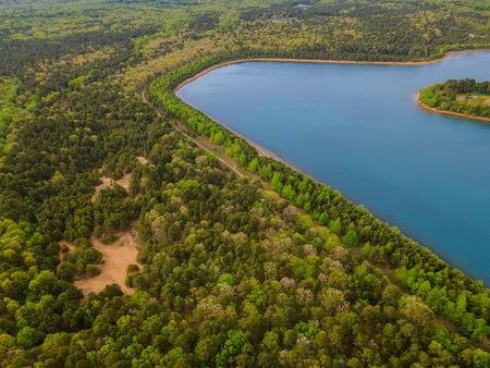 Green forest in sunny summer day on a beautiful panorama aerial view of near blue lakes