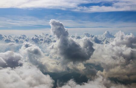 Clouds sky in seen through window of an aircraft under high clouds located