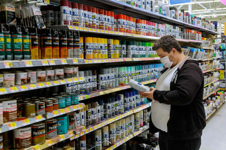 New York, NY USA - JUNE 14, 2020: A man wearing a protective mask in buyer selects paint in the store walmartのeditorial素材
