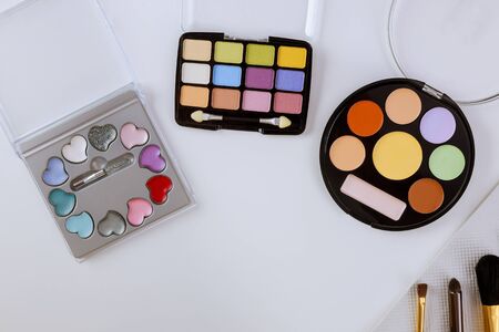 Palette of multicolor cosmetic make up with a eyeshadow palette, colorful shadows minimalism on isolated white backgroundの写真素材