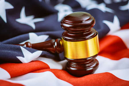 Wooden judge hammer on american flag of office Justice and law