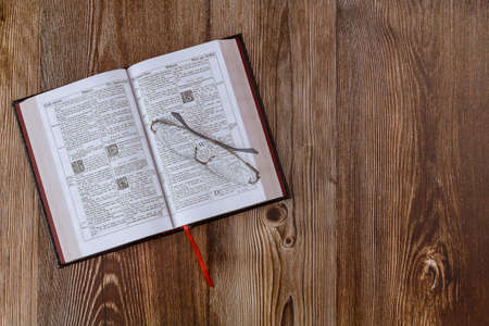 Los Angeles CA US 01 JULY 2020: Desk table opened the Holy Bible close up prayer time on eyeglasses