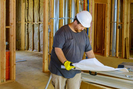 Architect construction of houses civil engineer checks the plan construction project work on wear...
