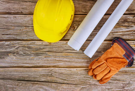 Builder of architects blueprints working on engineering office construction plans safety gloves on...