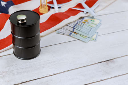 Concept sale of rising price of industry oil barrel tank container of US paper currency USA flag model plane airplaneの写真素材