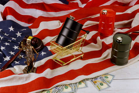 Oil of the black barrel of oil of one hundred US dollar bills on a flag in the USA court showdowns...