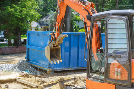 Group of excavator working on a construction site mini excavator and trash container construction dumpstersの写真素材
