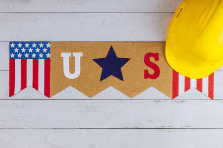 Happy federal holiday Labor day construction yellow helmet on US old wood background.