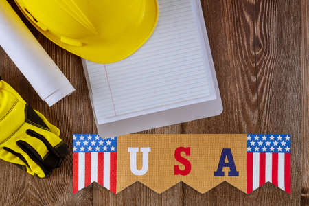 Engineer working on office desk with blank notebook construction protective yellow safety helmet on...