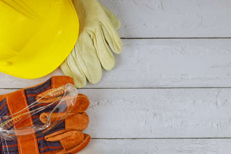 Construction work safety protective equipment with yellow hard hat helmet and a pair of working...