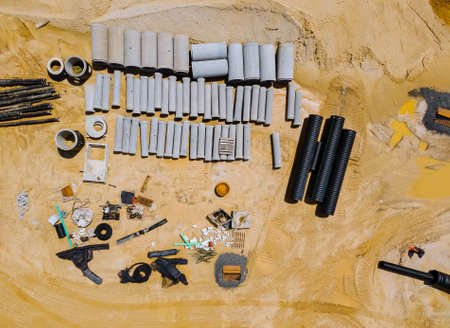 Water and sewage pipes stacked in ground during plumbing construction site