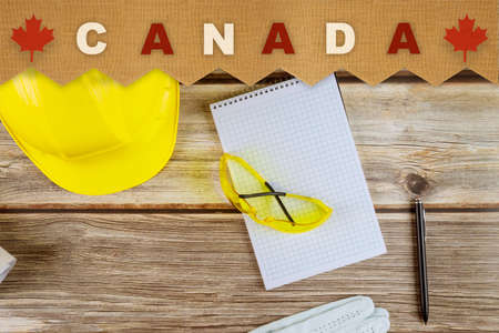 Happy labor day in yellow helmet, national patriotic with Canada on old wooden boardsの写真素材