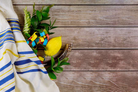 Religious yellow citron etrog, leaf lulav with jewish holiday of Sukkot on kippah and tallit