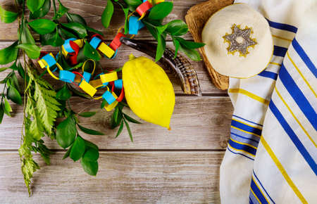Jewish festival of sukkoth over paper colorful chain garland on species lulav kippah